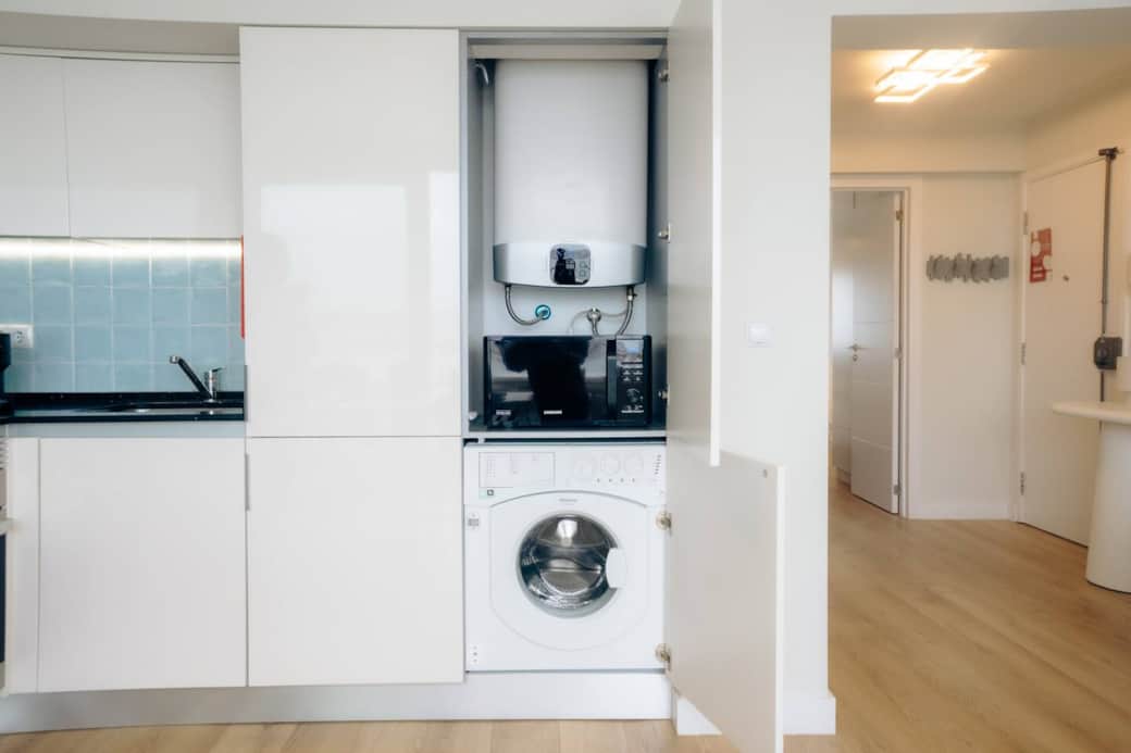 Essential amenities like the washing machine, microwave, and hot water heater are conveniently tucked away.