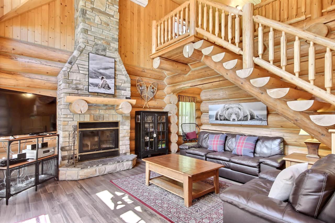 Cathedral-ceiling living room with fireplace and log stairs