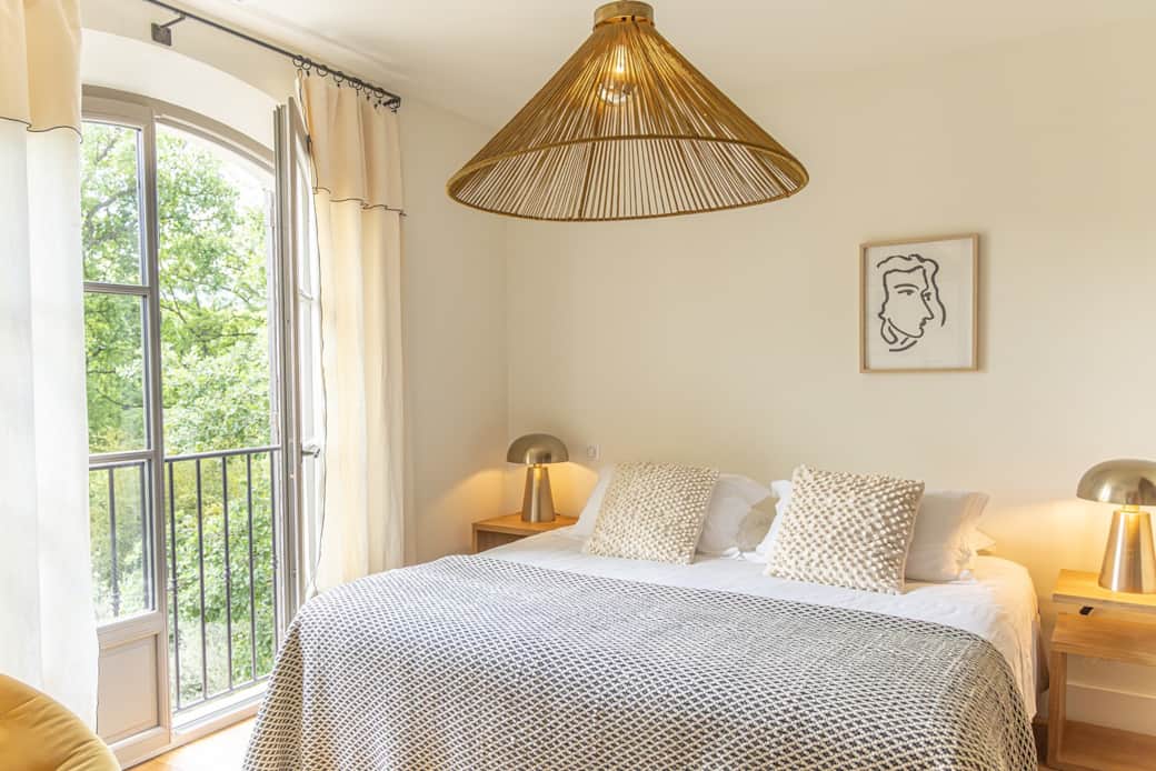 Chambre lit suspension rotin dore fenetre arche jardin bastide du couchant saint remy de provence
