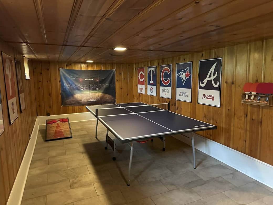 Finished basement with regulation size ping pong table and cornhole set.