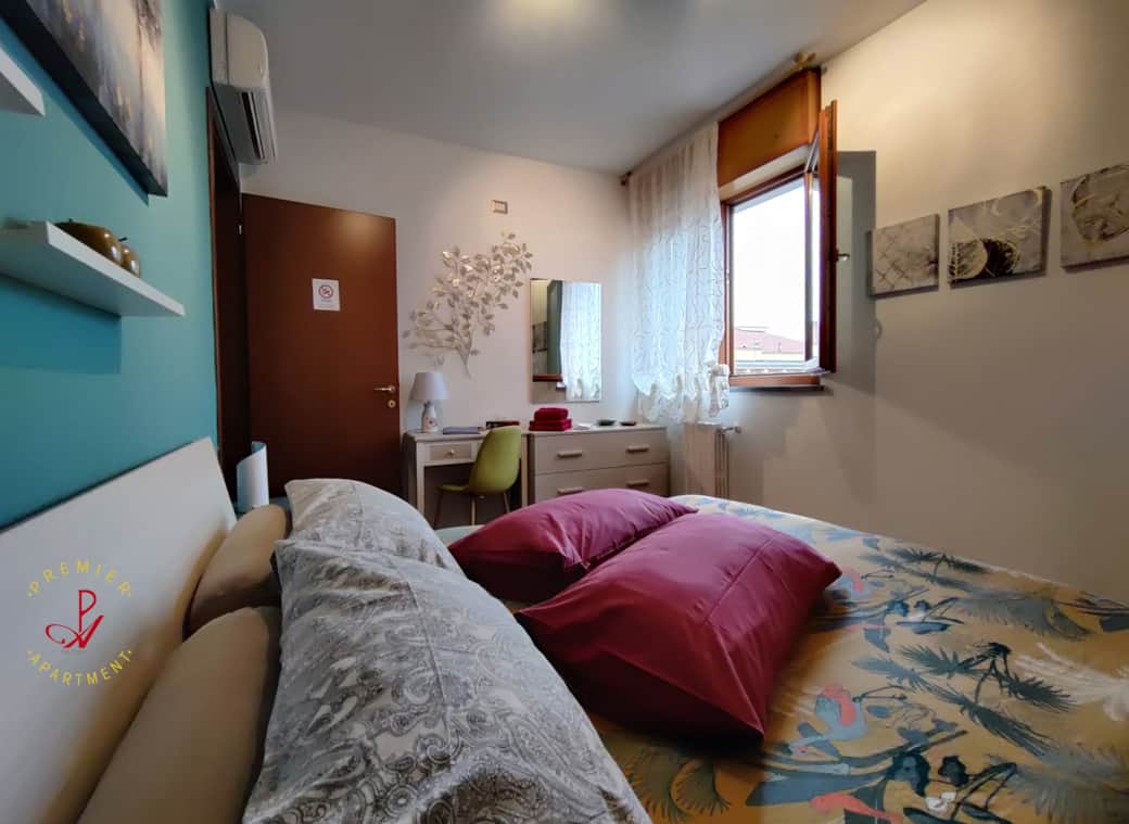 Dormitorio con escritorio, cómoda y espejo.