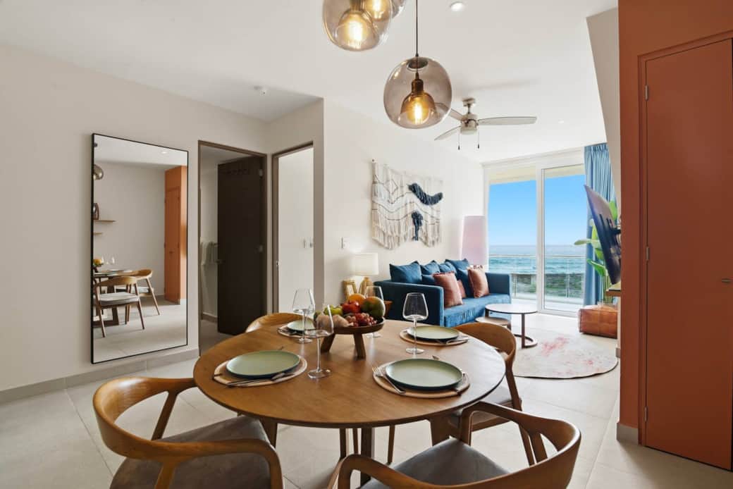 Inviting dining area with seating for four and full dinnerware, perfect for enjoying meals while taking in views of the Caribbean Sea. Inviting dining area with seating for four and full dinnerware, perfect for enjoying meals while taking in views of the Caribbean Sea.
