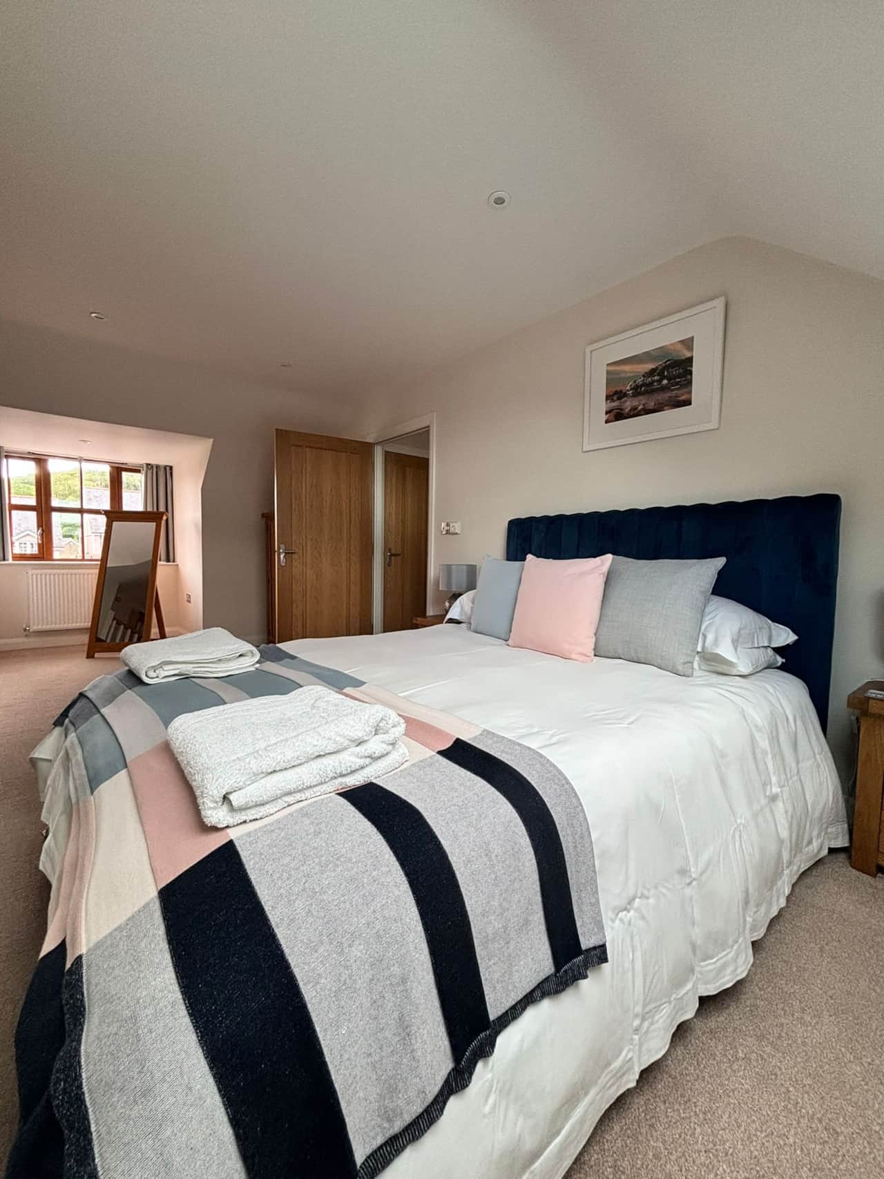 Serene bedroom with plush blue headboard and stylish accents.