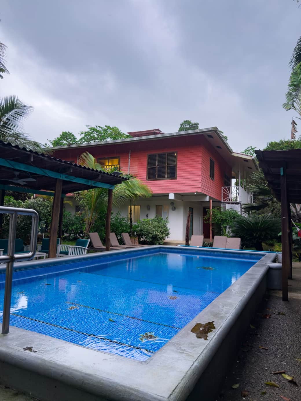 View of the private pool with the main house in the background. Lounge chairs line the pool deck, perfect for relaxing after a day at Bluff Beach in Bocas del Toro.
