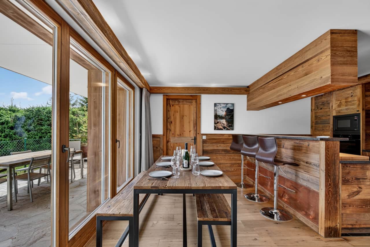 Espace repas ouvert sur le séjour, lumière naturelle et vue montagne.