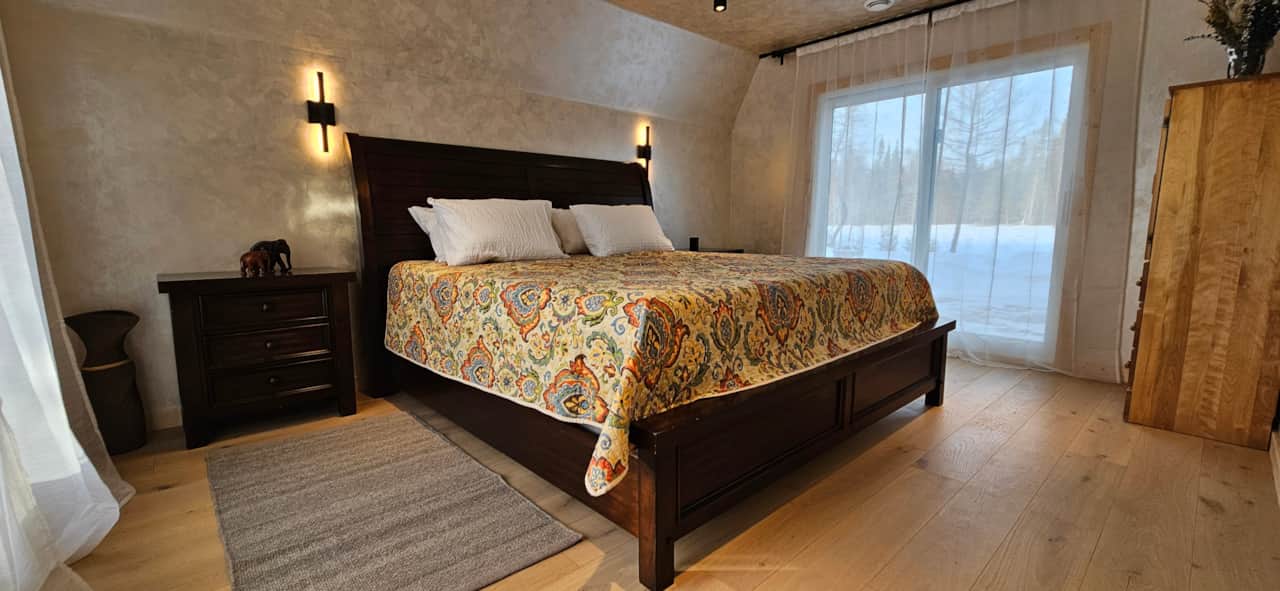 Spacious Primary Bedroom with King-Size Bed, Natural Wood Furnishings and Forest Views