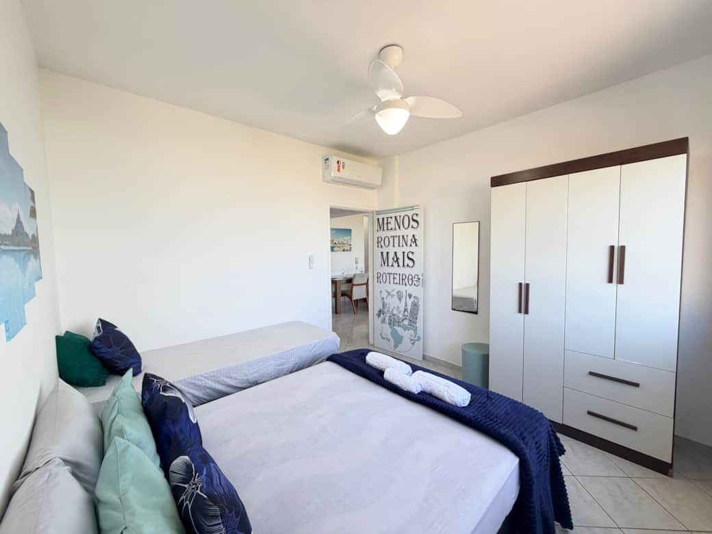 Quarto principal com cama de casal, cama de solteiro e ar-condicionado em apartamento para aluguel p