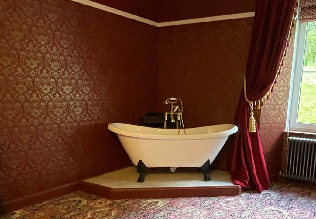 The Red and gold bedroom has a bath within the room