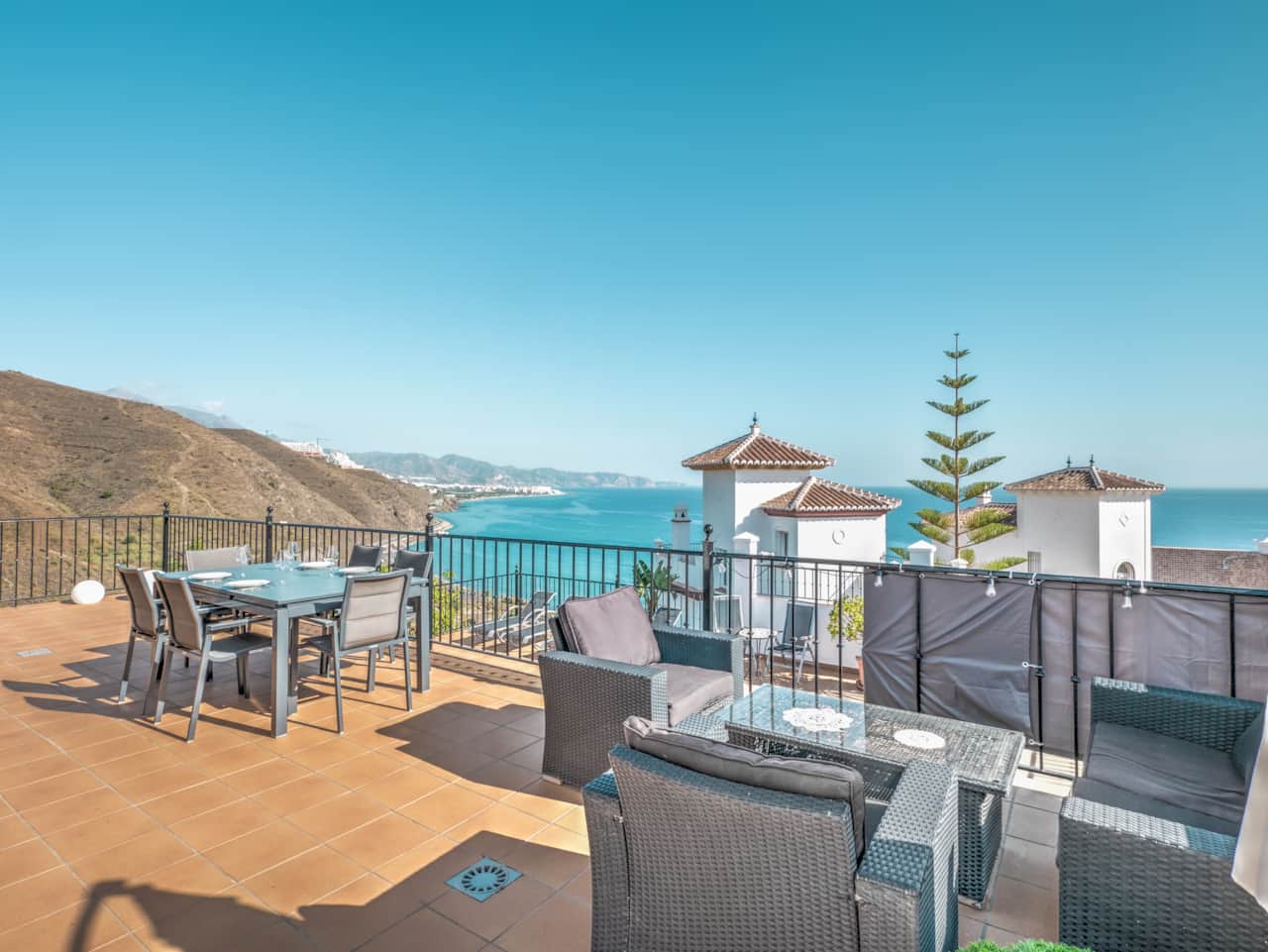 La terraza superior con zona de estar y mesa de comedor.