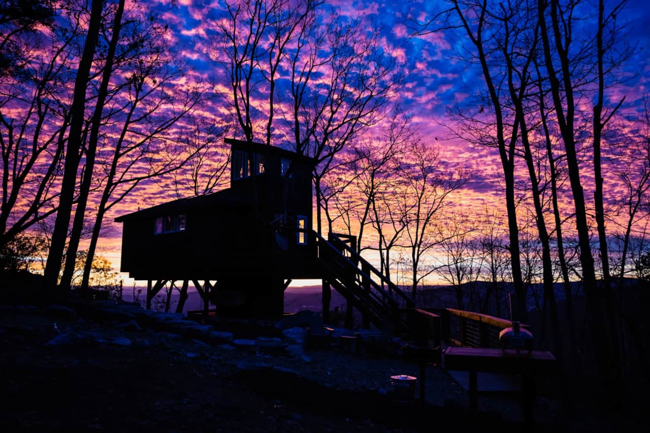 Sunset settles over the treetops in soft, fading mountain light.