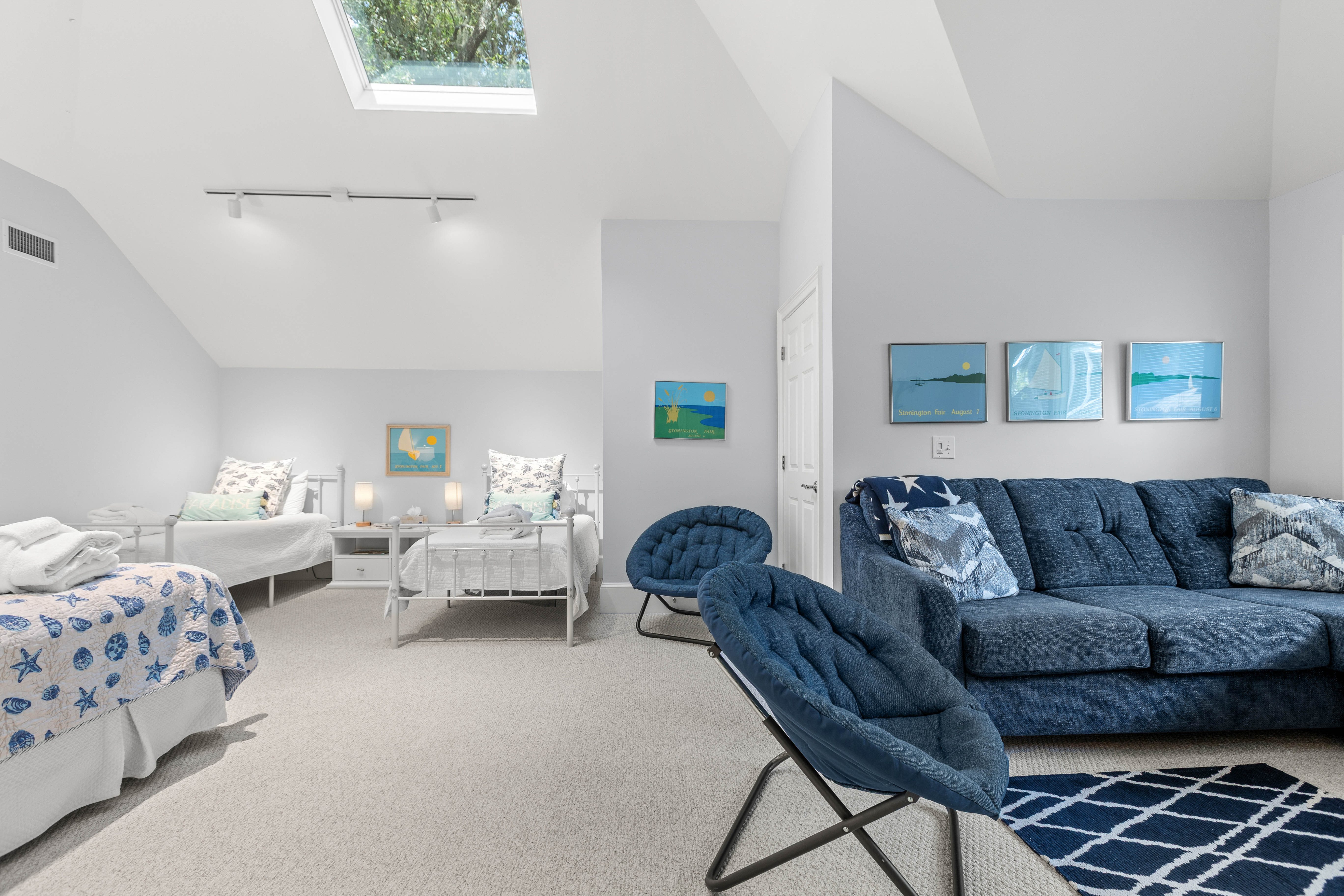A sitting area with sofa and chairs at one end of the room