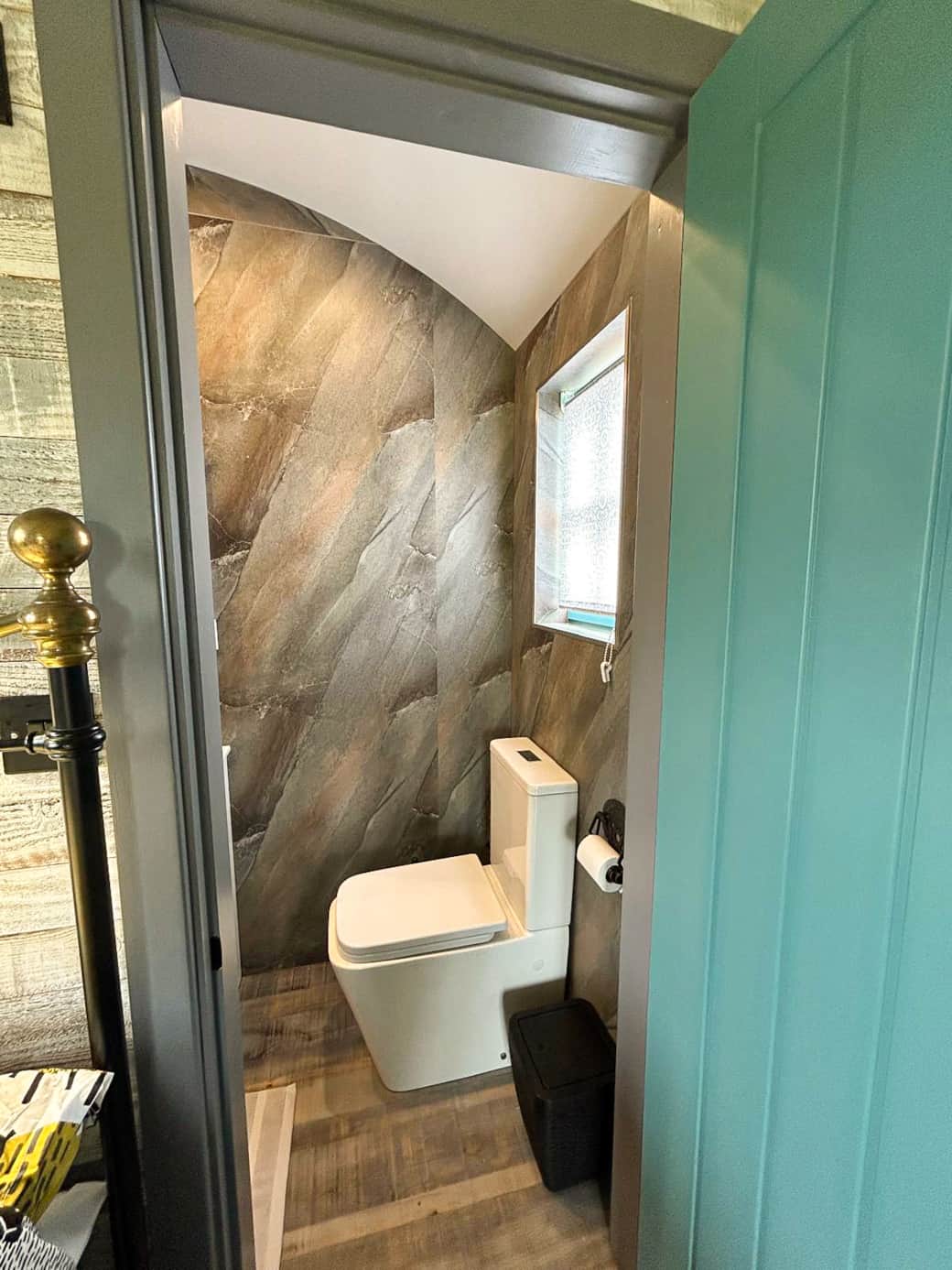Private WC with stylish stone-effect walls and modern fittings.