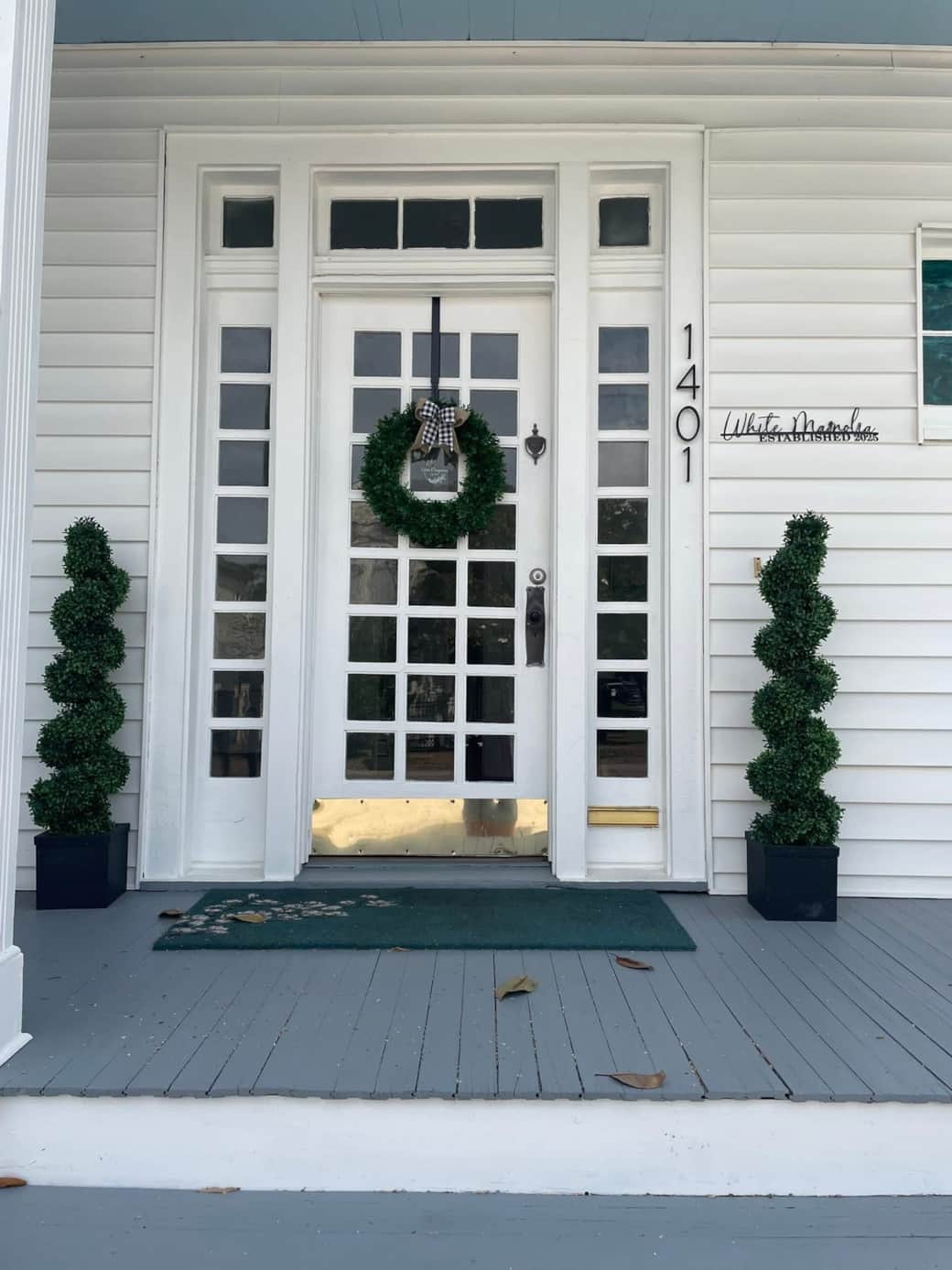 Front door with wreath and topiaries