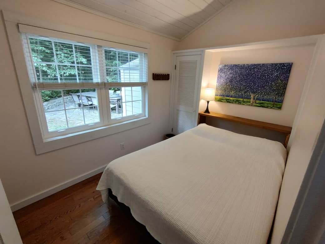 North queen bedroom looking  out over the side yard. The painting is "Garden Lights", oil on canvas (2024).