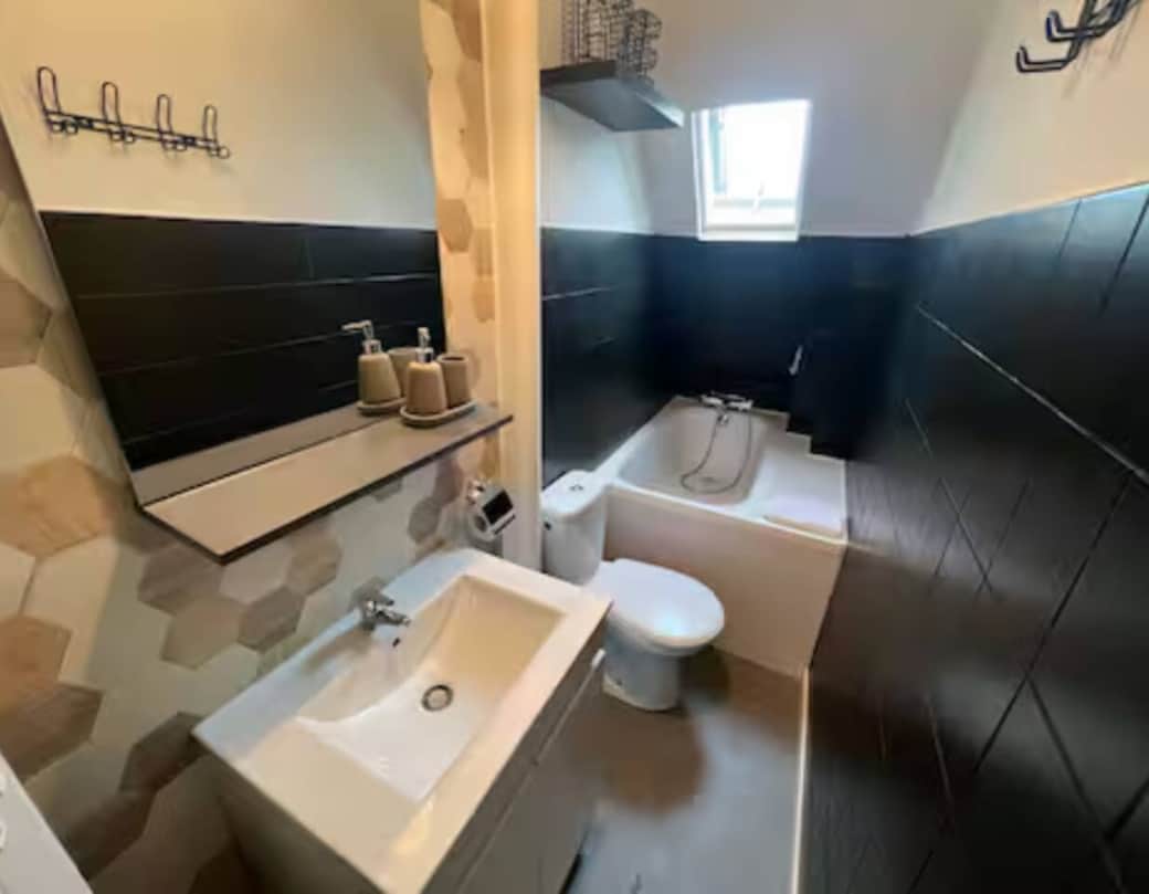 Salle de bain propre et lumineuse avec baignoire relaxante, WC et serviettes fournies – commencez la journée en pleine forme