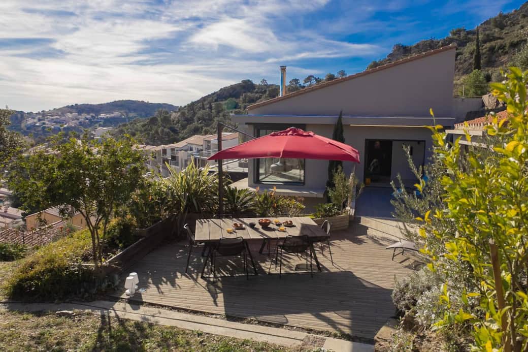 Un espace extérieur soigneusement paysagé, avec végétation méditerranéenne et terrasse bois. Idéal pour des apéritifs au soleil ou un dîner sous les étoiles en toute intimité.