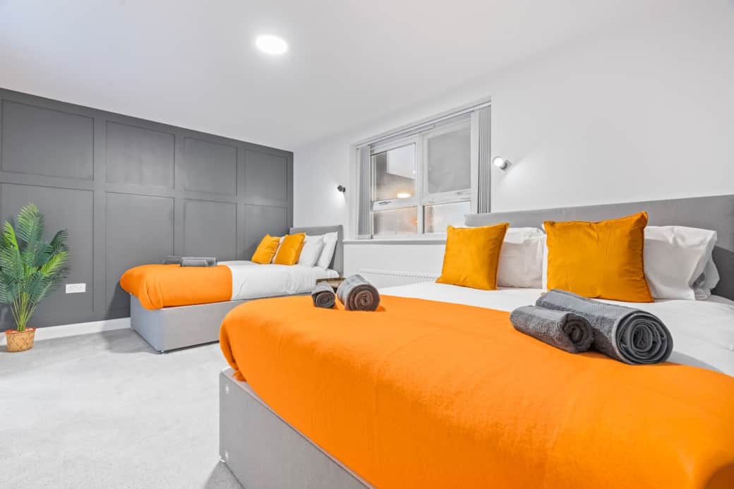 Bedroom 1:
Spacious, modern bedroom featuring a king bed and a double bed, styled with bold orange accents. Perfect for families or groups wanting comfort and space - complete with a private ensuite featuring a sleek shower and toilet.