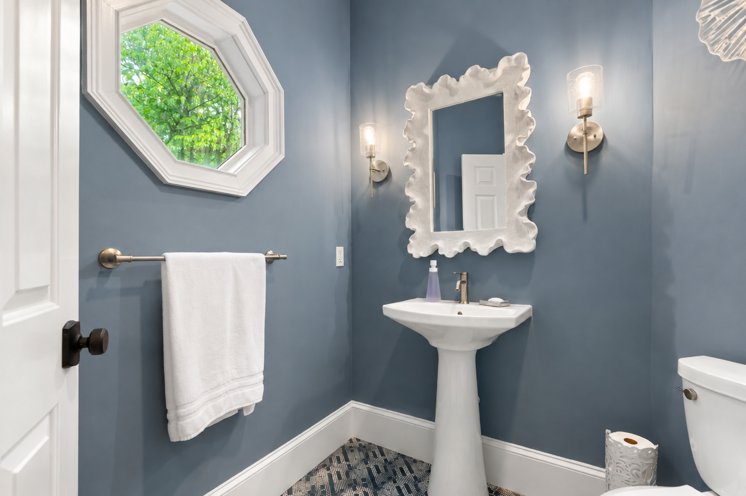 Freshen up in this cozy half bath with a pedestal sink, fresh towel, and natural light from the wind