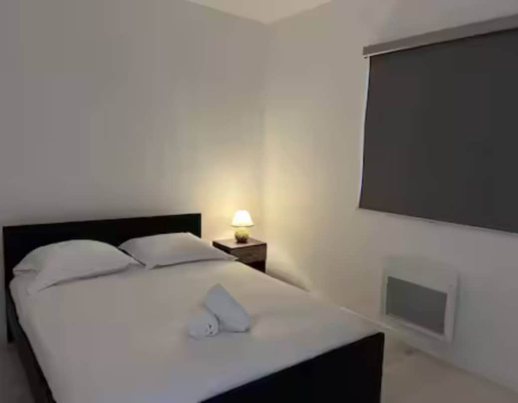 Chambre double élégante avec linge frais et éclairage doux pour des nuits reposantes.
