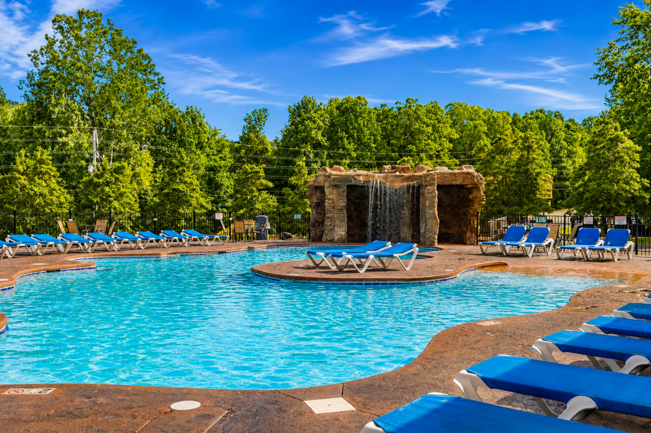 Relax by the resort pool on a sunny Smoky Mountain day, featuring plenty of loungers and waterfall