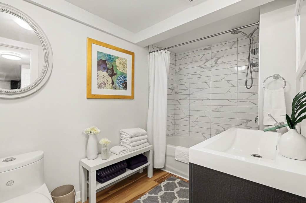 Refresh in the sparkling clean bathroom, complete with a modern vanity, large mirror, and plush towels in Ottawa.
