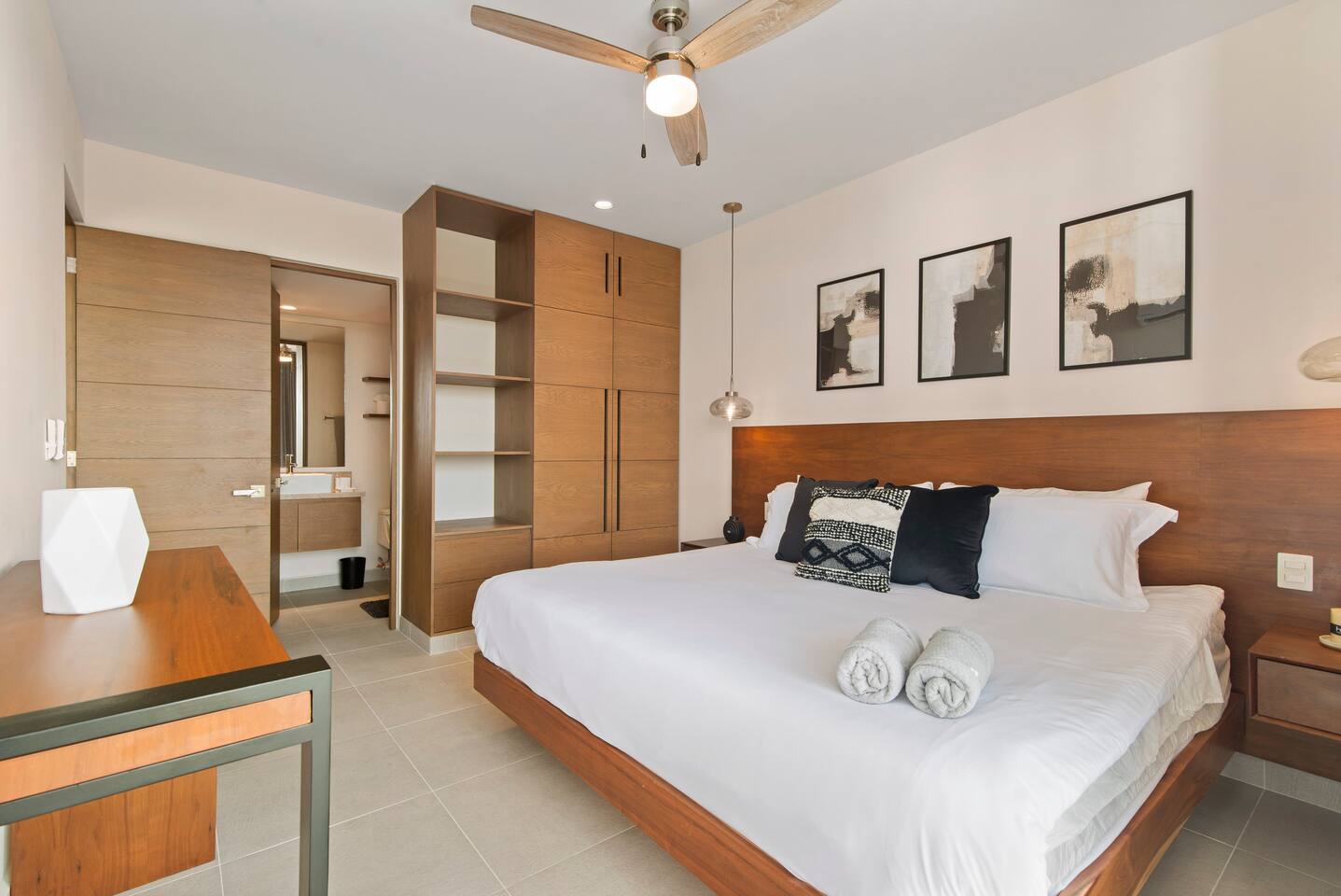 This spacious bedroom not only features a king-size bed, private balcony with Akumal jungle views, AC, a ceiling fan, and room-darkening shades, but also offers a full wardrobe and private en-suite bathroom for added comfort and convenience.