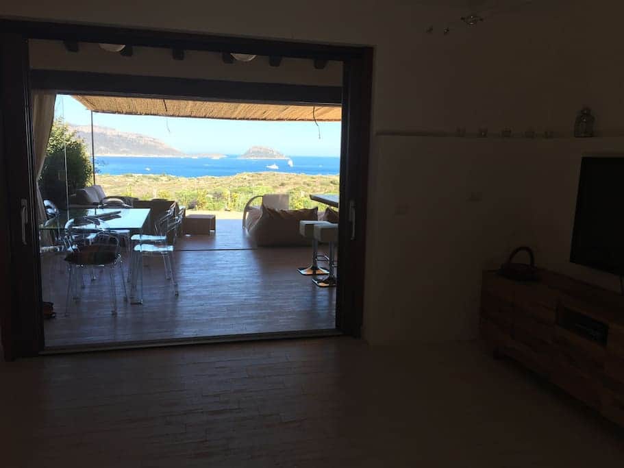 Soggiorno, affaccio verso la cucina esterna con tavolo da pranzo Soggiorno, affaccio verso la cucina esterna con tavolo da pranzo