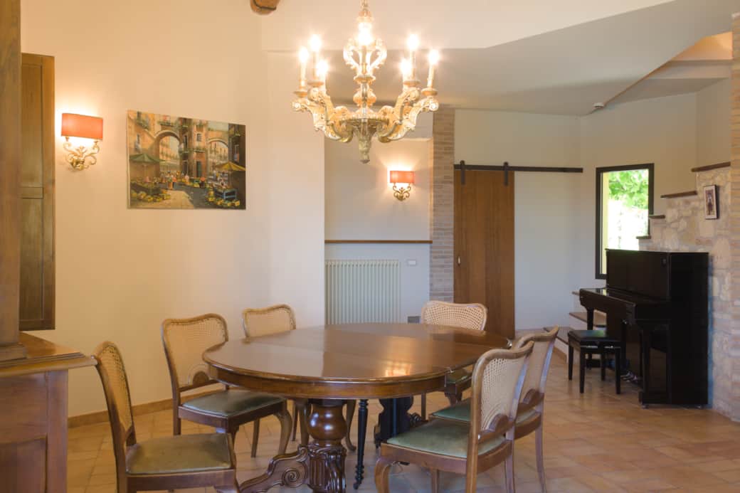 Salone con tavolo da pranzo e pianoforte