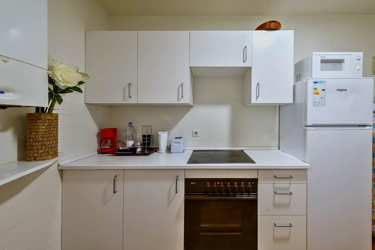 Cocina equipada con horno, vitrocerámica y nevera