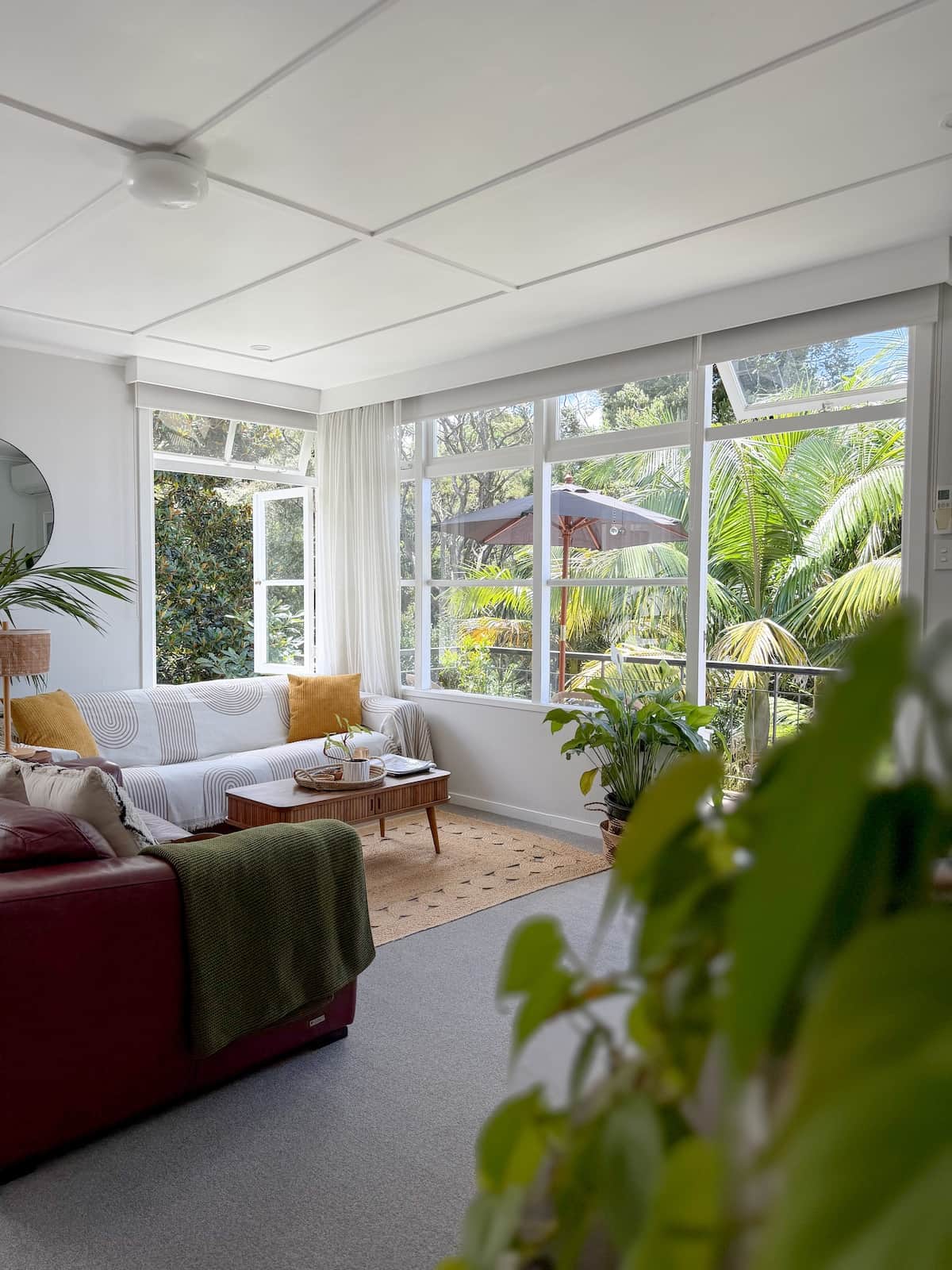 Sunny, light-filled lounge with a funky retro vibe, art and lush plants. Relax with bush and cityscape views, stunning sunrises, a 65” Smart TV with Netflix & Freeview, plus year-round comfort from the heat pump.