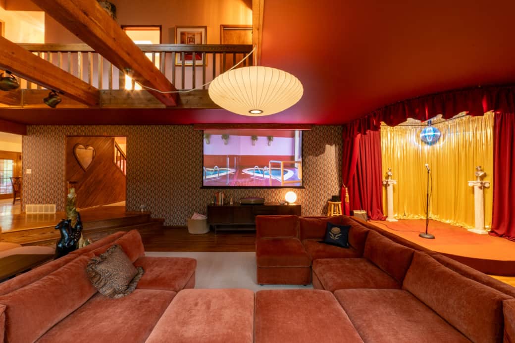 Expansive living room with a built-in stage, disco ball, and a 120” 4K home theater for movie nights Expansive living room with a built-in stage, disco ball, and a 120” 4K home theater for movie nights