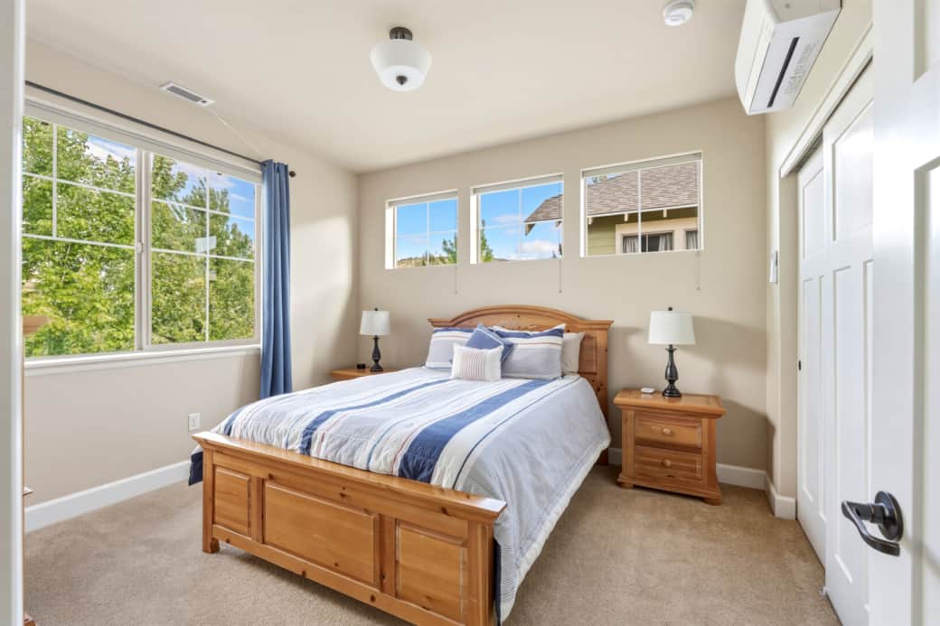 Upstairs queen bedroom with treetop views, natural light, and mini-split AC/heat.