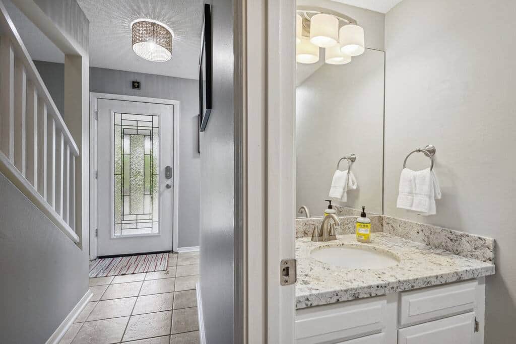 Interior view of front door and half bath is off downstairs hallway.