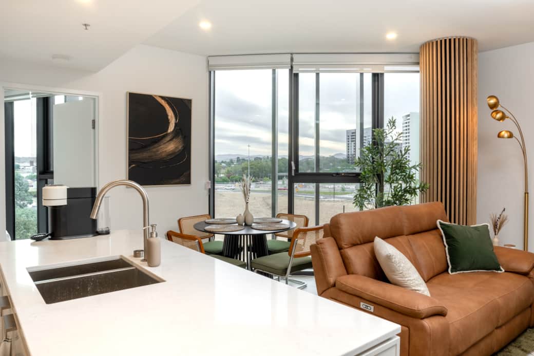 Open-plan kitchen, dining, and living area with expansive city and landscape views.