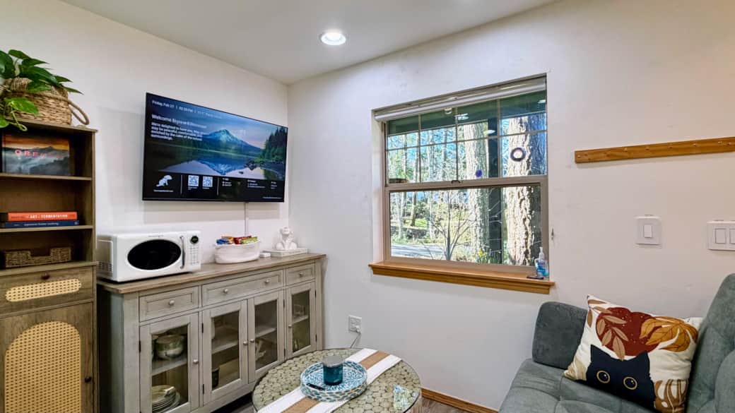 Relax in the living room with a sofa that easily converts into a bed, warm lighting, and a smart TV 