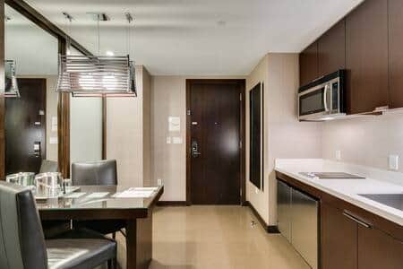 Fully equipped kitchenette with microwave, sink, and breakfast bar
