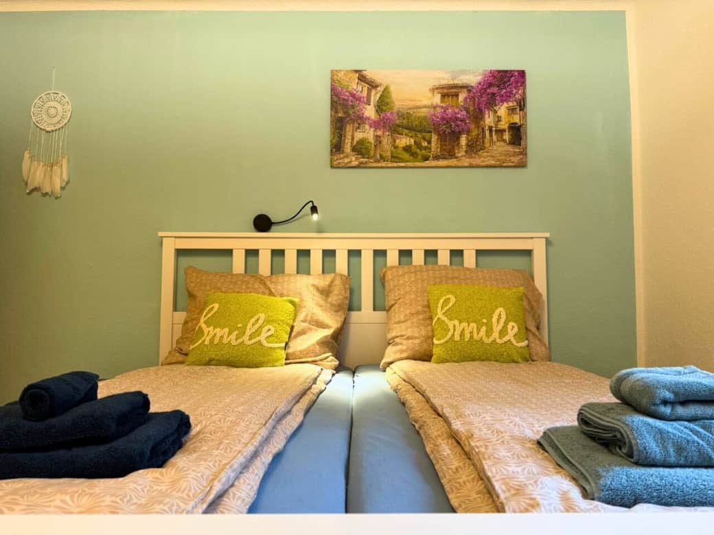 Schlafzimmer mit einem Doppelbett. Fenster mit Blick auf den angrenzenden Fluss