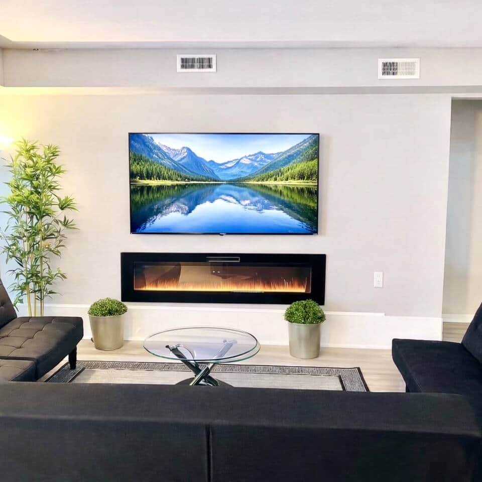 Spacious, modern living area with a 65” smart TV, three futon sofa beds, cozy fireplace, and a large balcony—perfect for relaxing. Openly connected to the kitchen and dining area for easy entertaining.