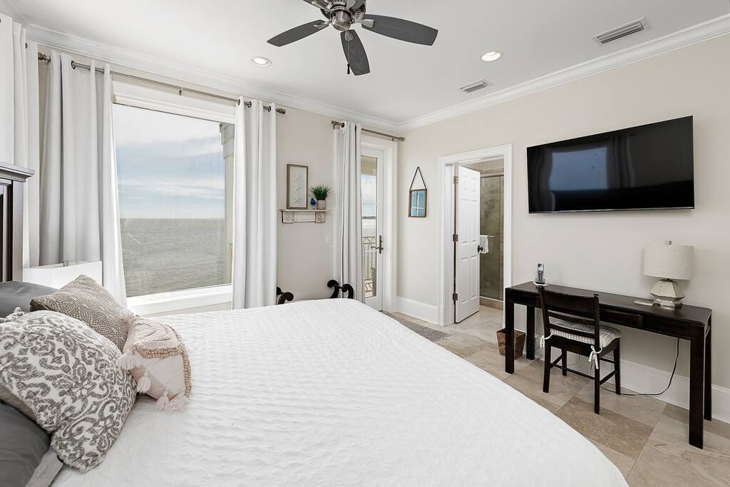 Third floor bedroom with large flatscreen tv and work area.  Bathroom has ensuite attached.