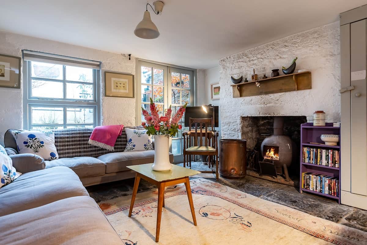 Cosy Sitting Area Boasting Unique Handmade Pot-Belly Stove and Double Doors Leading to Outdoor Courtyard.