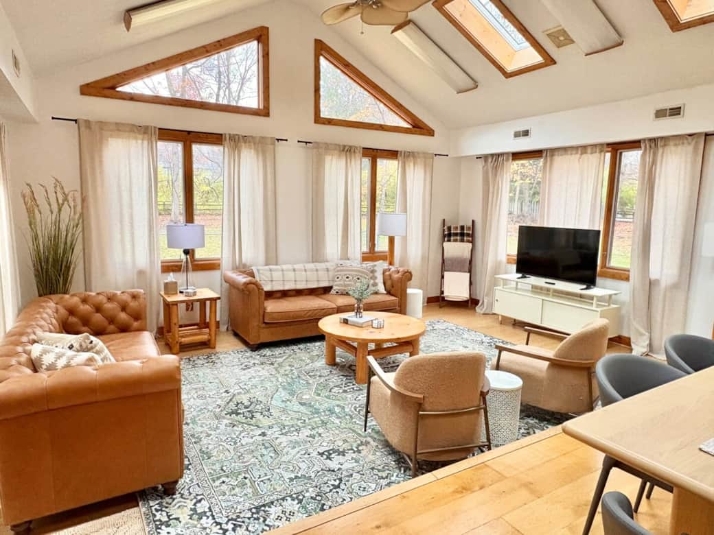 Bright and inviting living room with vaulted ceilings, skylights, and oversized windows that fill the space with natural light.
