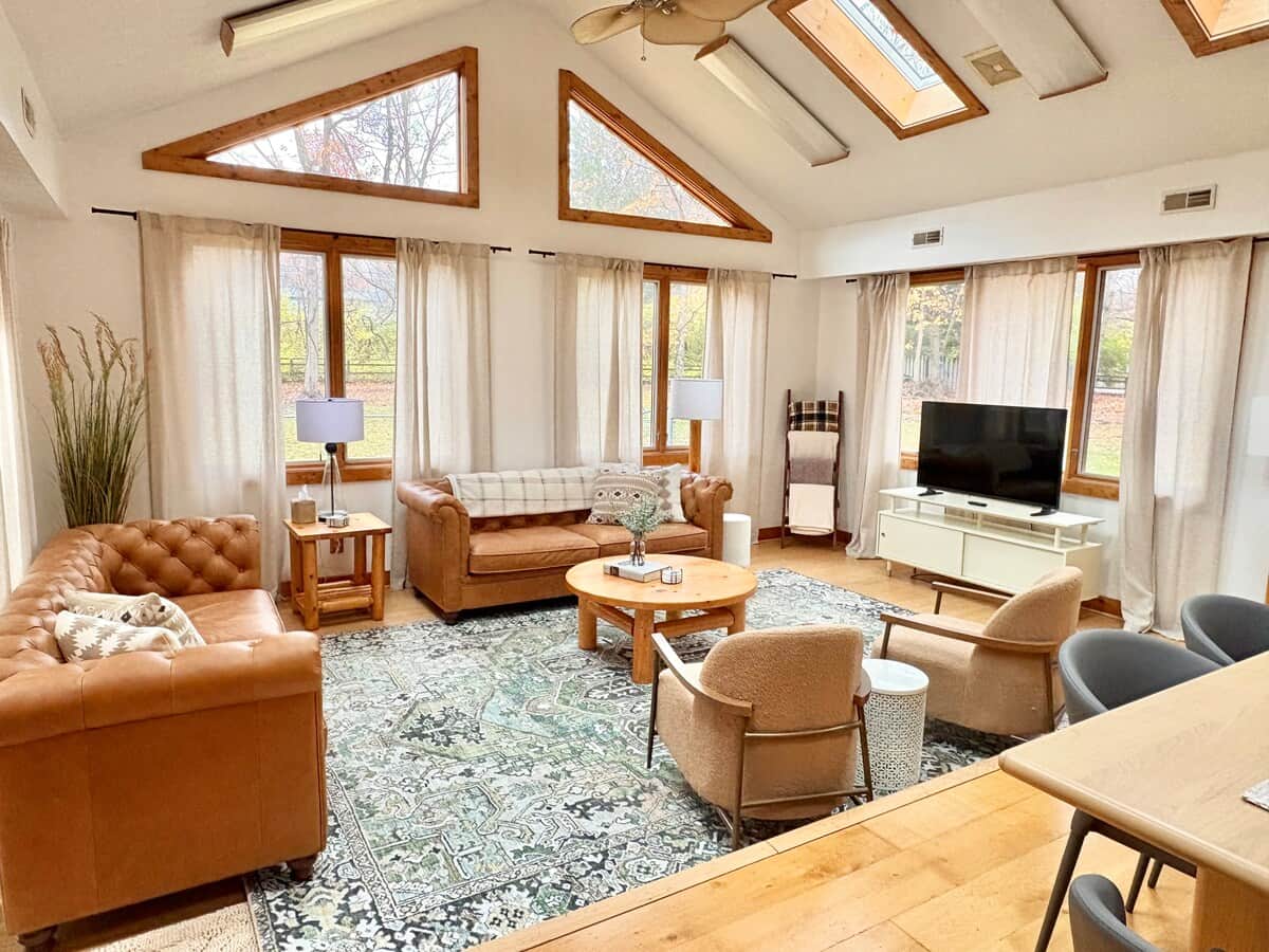 Bright and inviting living room with vaulted ceilings, skylights, and oversized windows that fill the space with natural light.