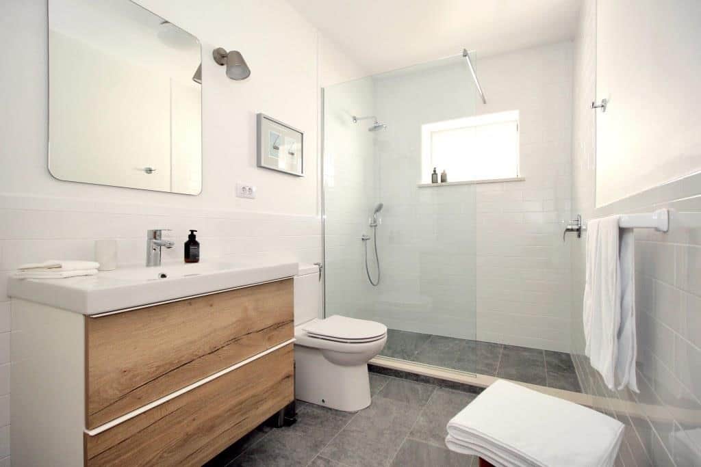The modern, up-to-date bathroom has a large sink, spacious, walk-in shower and heated tile floor.