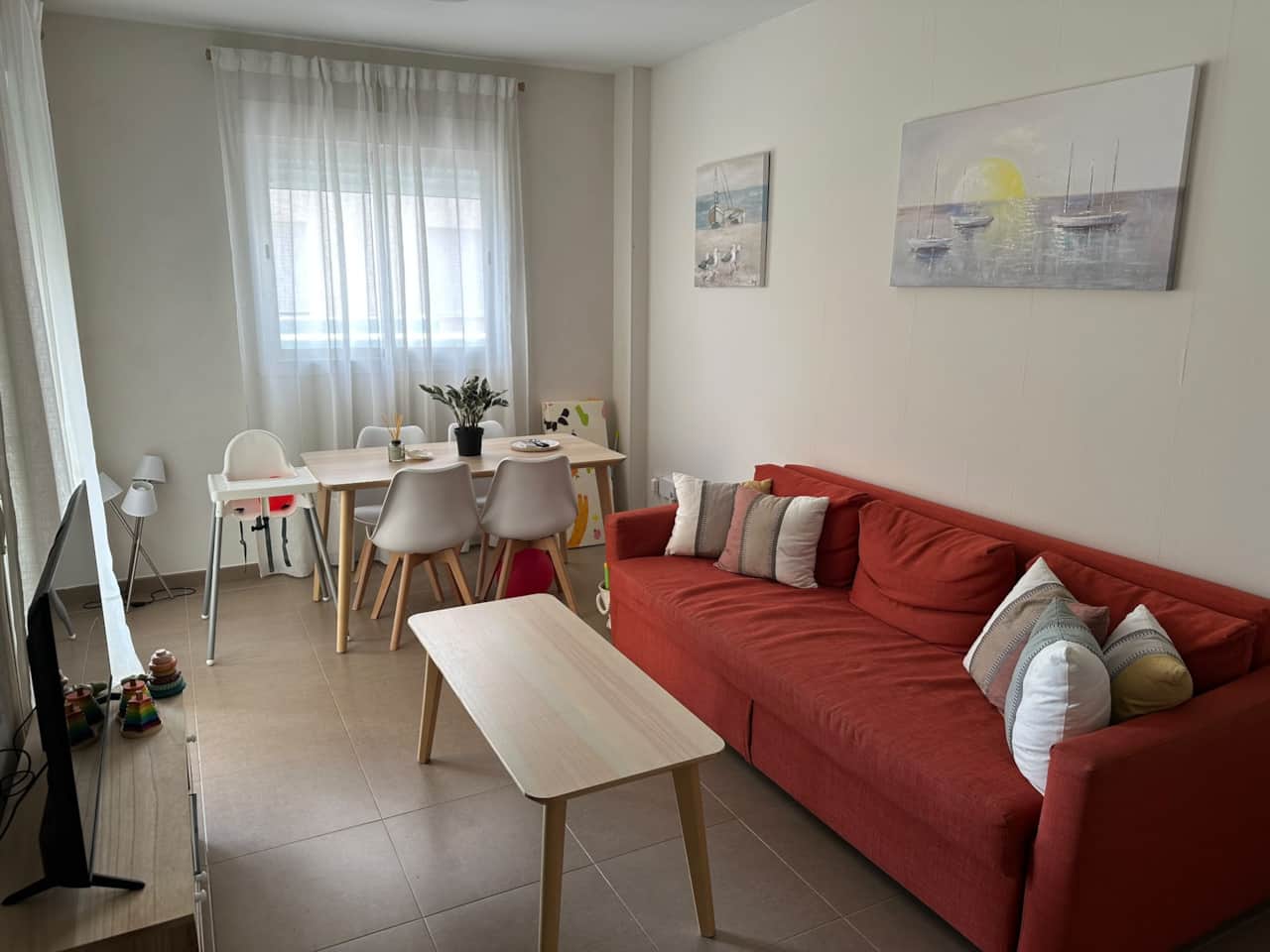 Salón luminoso con sofá cama, Smart TV y mesa de comedor