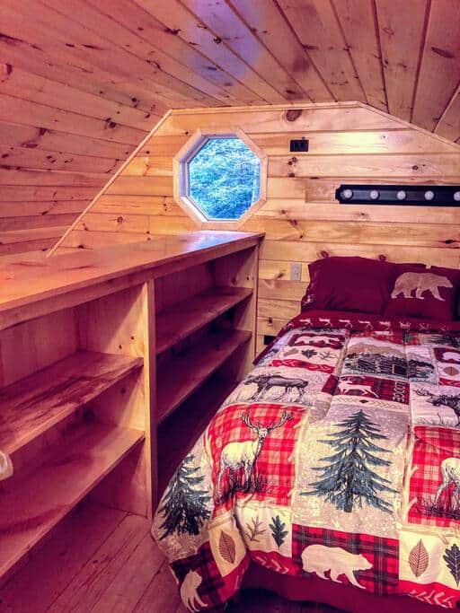 Cozy loft space with a double bed and ship window.