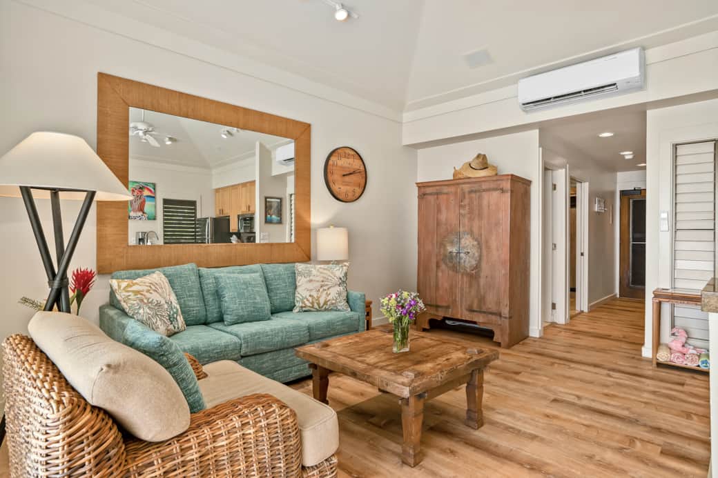 Comfy living with split A/C, plush sofa, rustic armoire, and island decor—unwind after sunny day