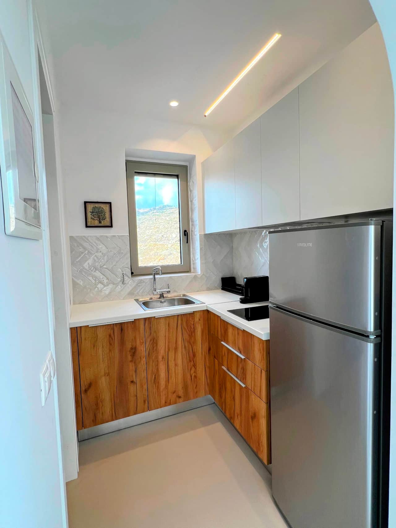 Fully equipped kitchen with wooden cabinets and natural light, stone house, Kea