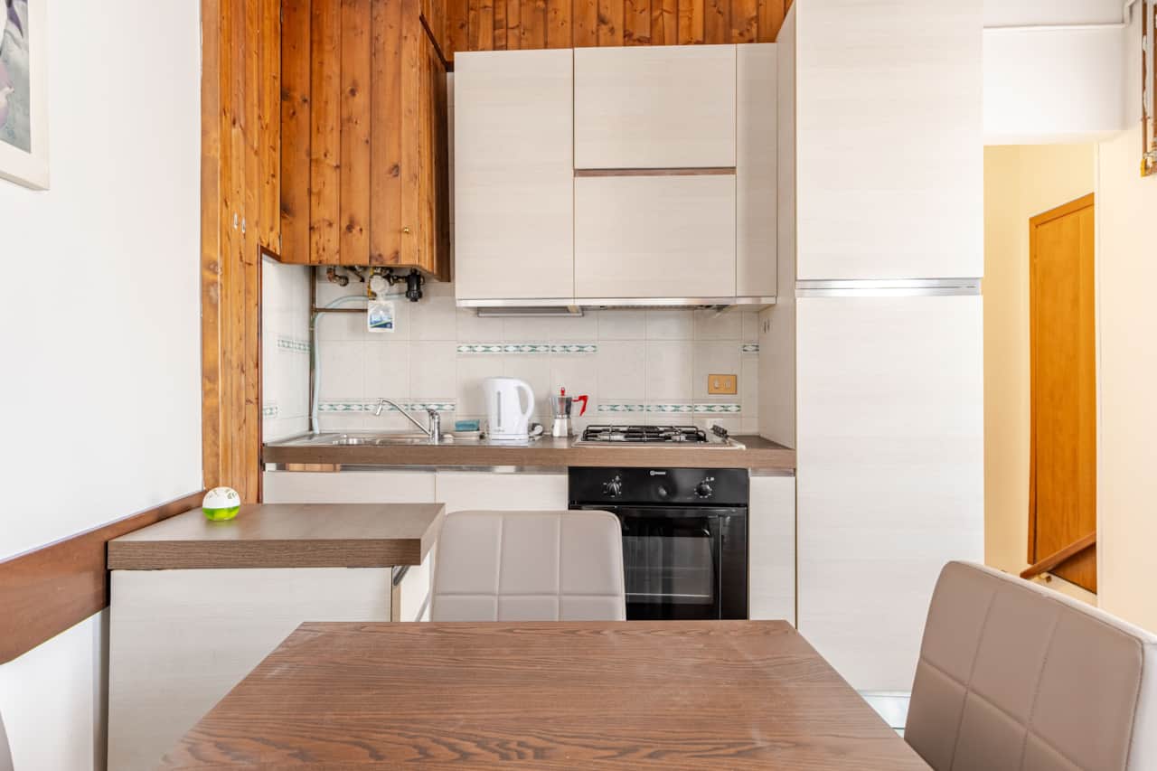 Cuisine avec table en bois, four et plaques de cuisson