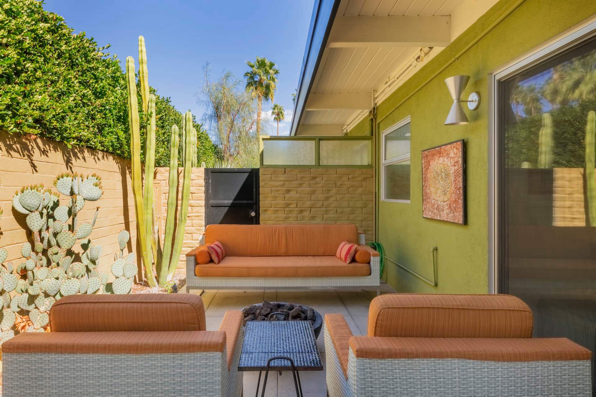 a small outdoor seating area with a fire pit and cacti