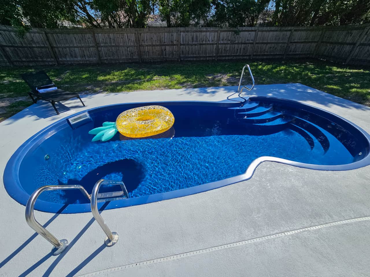 Pool has Ladder and Stairs with Sitting Bench